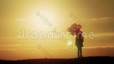 日落时分，坐着<strong>气球</strong>在田野里散步的<strong>剪影</strong>女孩。 日落时带着<strong>气球</strong>在田野里快乐的孩子。